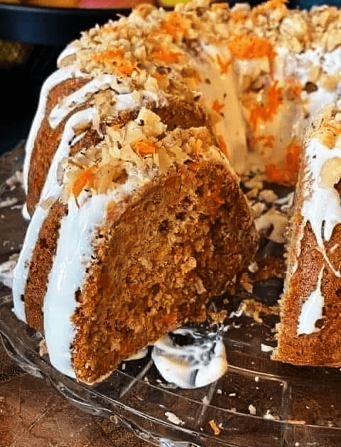 Carrot cake with cream cheese frosting topped with walnuts