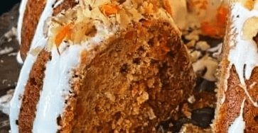 Carrot cake with cream cheese frosting topped with walnuts